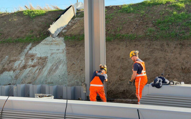 Waterbouwspecialisten voeren de laatste controle uit nadat de Prolock Epsilon kunststof damwand is gekoppeld en klaarstaat om te worden ingebracht tijdens dijkversterkingswerkzaamheden
